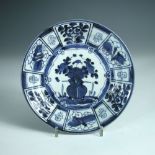 A 17th century kraak style blue and white plate, painted with a central vase of flowers within