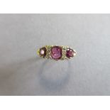 An Edwardian style 18ct gold ruby and diamond ring, with three graduated oval cut rubies separated