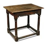 An oak side table - 17th century, with fret carved frieze rails, on stretchered turned column legs
