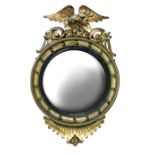 A Regency circular convex gilt framed mirror, with eagle and scroll carved cresting, plate size 44cm