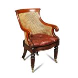 A Regency mahogany library bergere, the scroll carved crest rail to a curved back and lapit carved