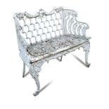 A French cast iron garden seat, with trellis decorated back and sides, on foliate cast legs 90 x 113