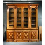 A Victorian blonde oak breakfront library bookcase - late 19th century, with applied scroll and leaf