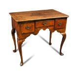 A Queen Anne burr walnut lowboy, with quarter veneer top, three small drawers with decorated brass