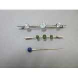 An ice white topaz brooch, a green grossular garnet brooch and a lapis lazuli stick pin, the first