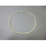 A choker length string of cultured pearls with Art Deco diamond clasp, the 4.3-7.7mm graduated