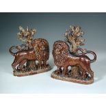 A pair of 19th century brown salt-glazed mantelpiece lions, probably Yorkshire, both standing before