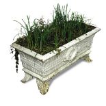 A cast iron garden trough shaped planter, decorated in relief with a fluted body and central wreath,