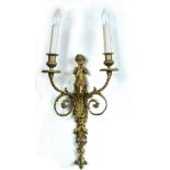 A pair of ormolu two-light wall sconces, each surmounted with a putto playing pipes above acanthus