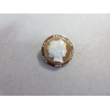A hardstone cameo and diamond brooch, of circular form depicting the head of a young woman in