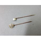 A diamond set stick pin and another set with a baroque pearl believed to be of natural origin, the