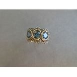 A light blue sapphire and diamond triple cluster ring, the oval cut light green-blue stones, one a