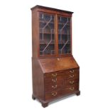 A George III mahogany bureau bookcase, with dentil moulded cornice, astragal glazed doors above a
