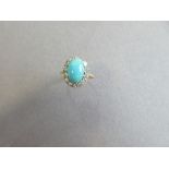 A turquoise and diamond cluster ring, the oval cabochon turquoise in a border of fourteen round