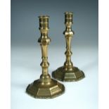 A pair of early 18th century brass candlesticks, the knopped stems with stepped octagonal bases (