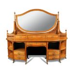 An Edwardian satinwood dressing table of demi-lune outline, in the manner of Maple & Co, with open