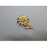 An 18ct gold and diamond set flower brooch, the flower stamen set with an open cluster of seven