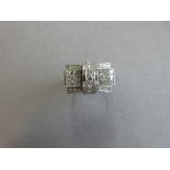 A diamond set bow ring, the short broad bow with tiered flares either side of the concave line of