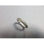 A diamond set band ring, designed as a solid wire hoop of 3.4mm diameter, gypsy set with eight round