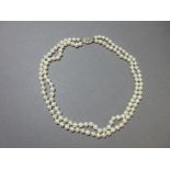 A two strand cultured pearl necklace with white gold and diamond clasp, the uniform 6-6.5mm pearls