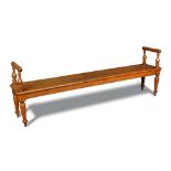A Victorian oak hall bench - late 19th century, with raised end rails and cushion moulded arm rests,