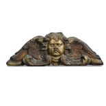 An early 19th century carved wood and parcel gilt winged cherub mask door cresting, carved in four