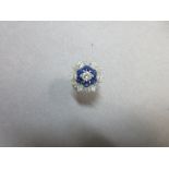 A sapphire and diamond cluster ring, of flowerhead form with a central round brilliant cut diamond