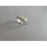 A modern five stone diamond ring, the uniform round brilliant cut diamonds claw set to a plain shank