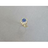A star sapphire and diamond cluster ring, the oval cabochon mid blue sapphire claw set in a border