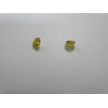 A pair of loose fancy vivid yellow round brilliant cut diamonds, each diamond weighing approximately