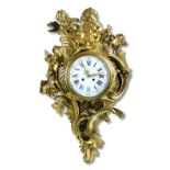 A French ormolu cartel clock, the 18th century heavy cast figural Rococo scroll case with cracked