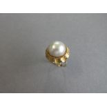 A mabé pearl flowerhead ring, the 14.7mm diameter mabé pearl collet and ropetwist set with a