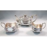 A George III composed three piece tea service, the teapot of compressed rectangular shape, ribbed