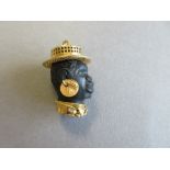 A Blackamoor pendant set in 18ct gold, the carved black head, realistically modelled, wearing a