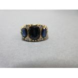 An Edwardian style 18ct gold sapphire and diamond ring, set with three graduated oval cut midnight