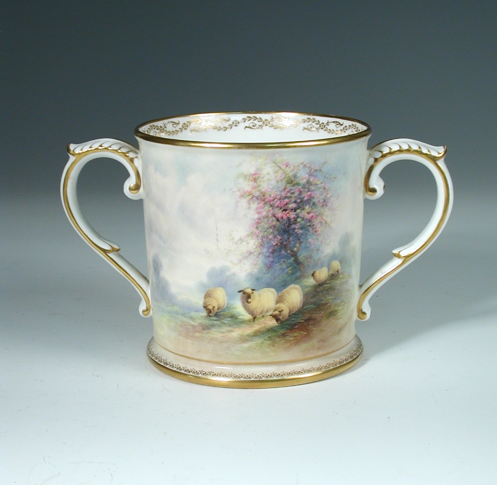 A Royal Worcester two handled loving cup, painted by E. Barker, signed, with sheep grazing beneath a
