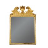 A George II giltwood mirror, with scrolling break-arch pediment and central cartouche, to a low