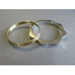 A 9ct gold reeded bangle together with a Mexican silver bangle, the gold bangle of uniform 7.3mm