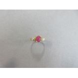 A cabochon ruby ring with diamond highlights, the oval cabochon ruby four claw set between bars