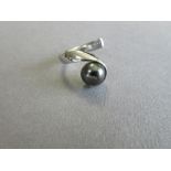 A platinum and cultured black pearl single stone ring by Paul Spurgeon, designed as a polished