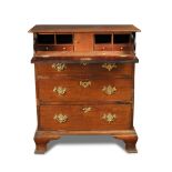 A small George III mahogany chest of four long drawers, with fitted secretaire drawer, cut brass