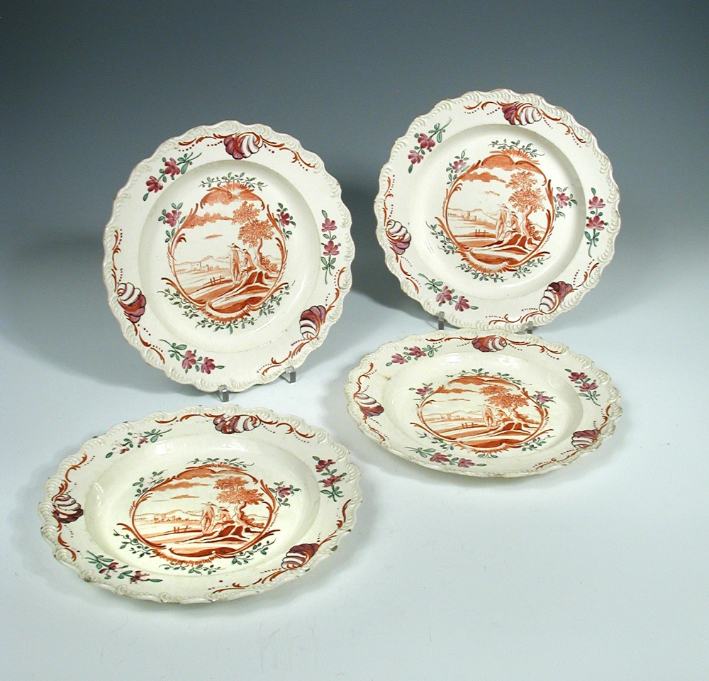 A set of four 18th century Leeds creamware plates, each painted to the centre in iron red with two