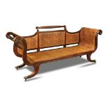 A Regency mahogany framed bergere settee, with a central rope twist carved bar back and scrolling