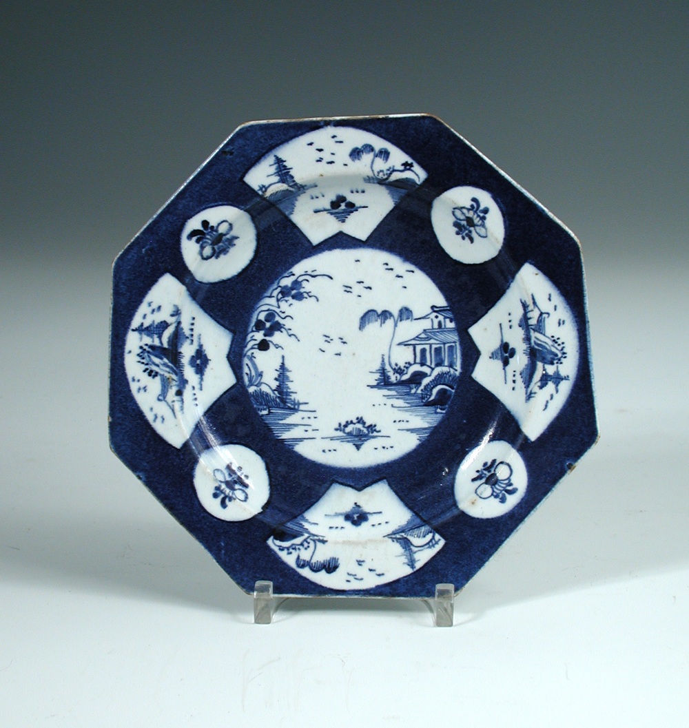 A Bow blue and white octagonal plate, circa 1765, the powder blue ground body reserved with a