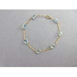 An aquamarine bracelet, composed of seven oval cut aquamarines separated by short lengths of