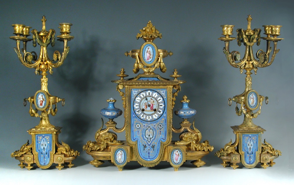 A 19th century French gilt metal and 'Sevres' porcelain clock garniture, the elaborate shaped case