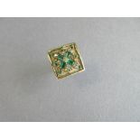An emerald and diamond dress ring, designed as a square textured plaque with raised polished edges