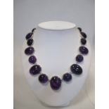 A modern amethyst rivière necklace, composed of graduated alternating round and oval cabochon
