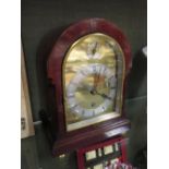 A figured mahogany domed top mantle timepiece with brass dial signed Pearce & Sons, Leicester, circa