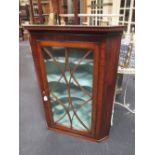 A Regency mahogany corner cupboard with box wood stringing to the astragal glazed door, to a